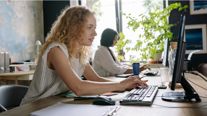 Two women doing administration work on a computer in an office