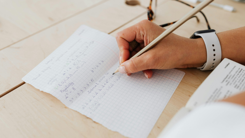 Women working out maths problems with a piece of paper and a pencil